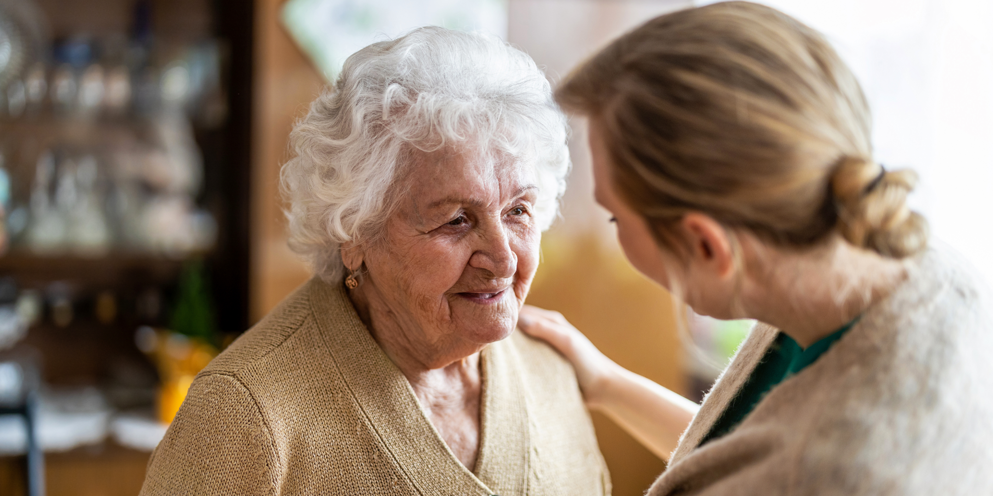 Carer comforting an elderly lady
